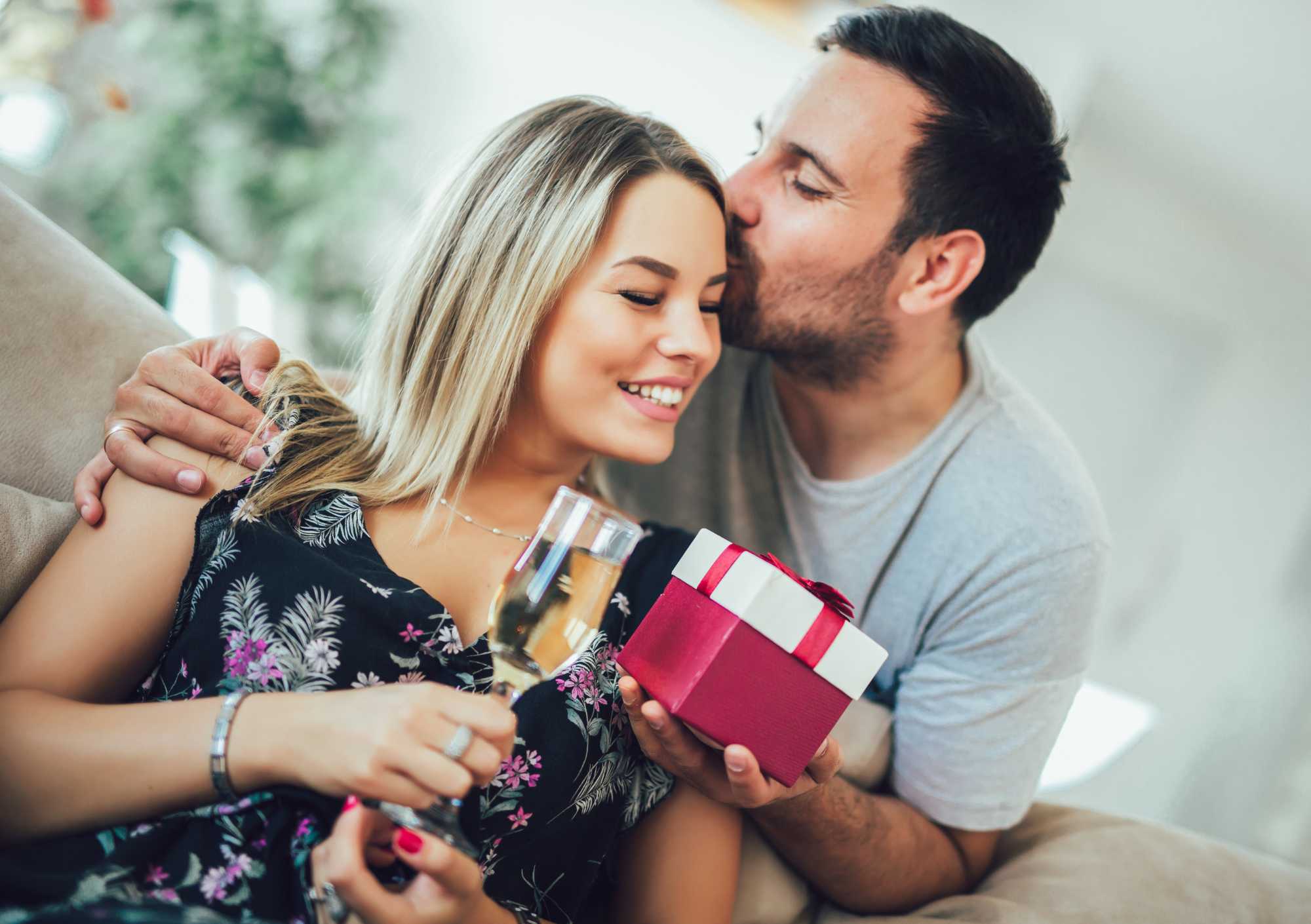 man giving girlfriend a romantic anniversary gift with champagne